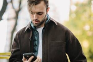 man scrolling on smartphone